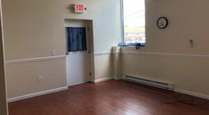A 600 SF office for lease in Allentown, featuring hardwood floors and a clock.