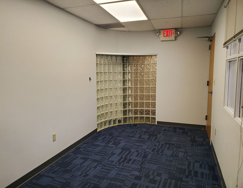 An office lease with a blue carpet and a door.
