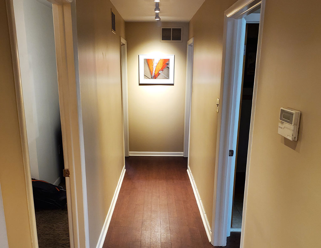 A spacious home hallway adorned with an elegant painting on the wall.