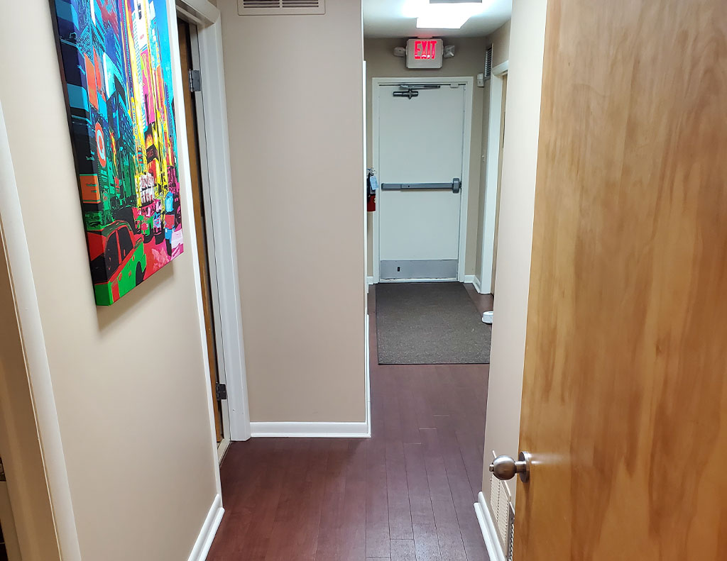 A hallway with a painting on the wall, featuring a 300 Sf office space available for lease.