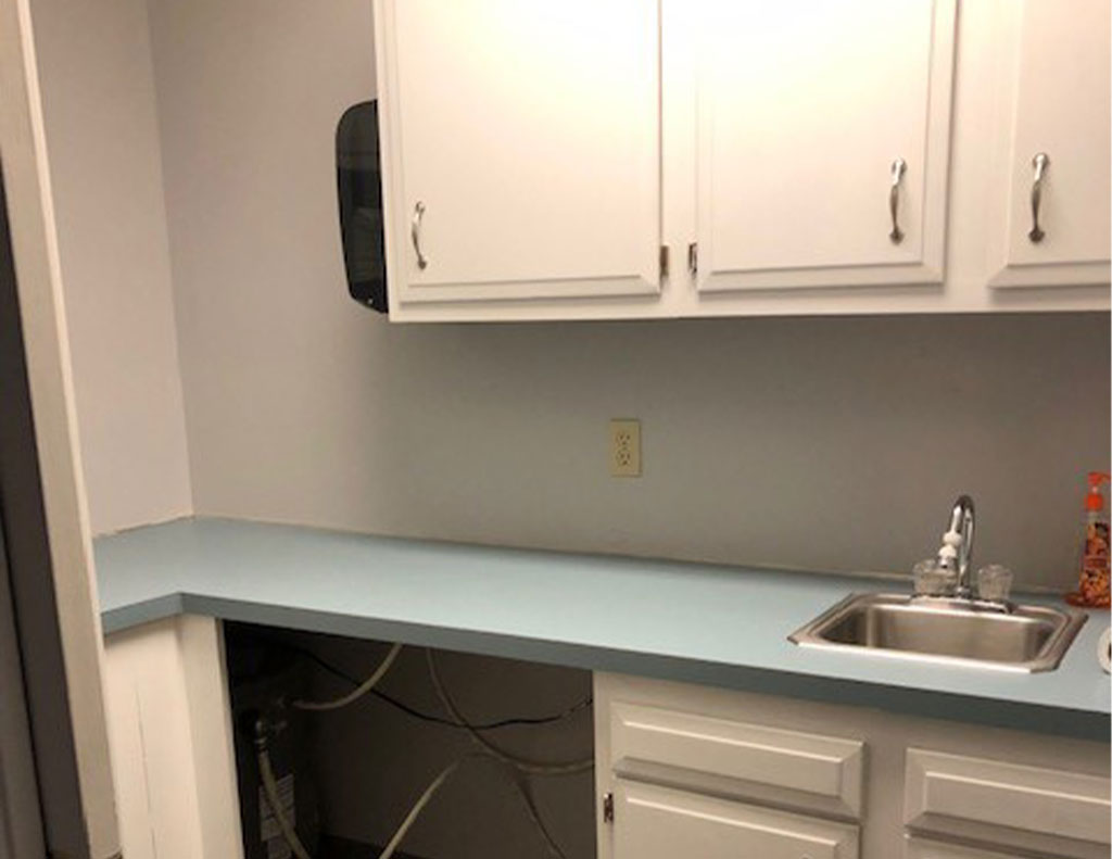 A kitchen inside an office with a wash basin