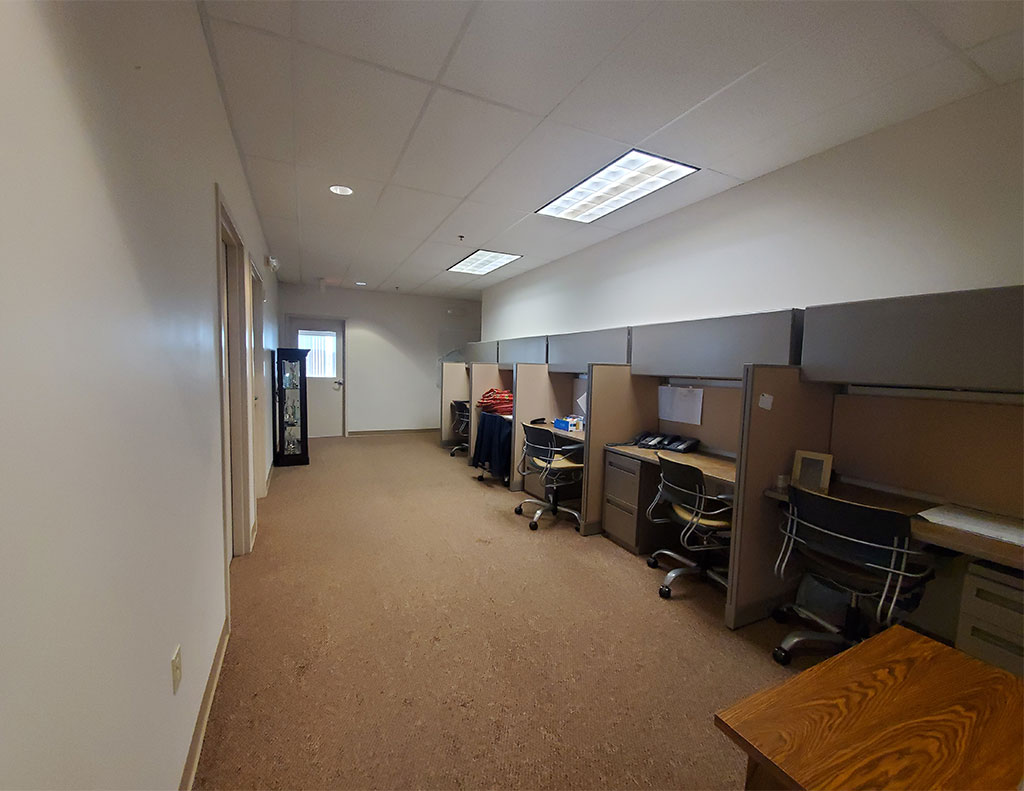 An empty office space with desks and chairs available for lease.